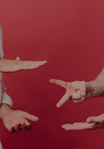 Two people play Rock paper scissors game on a red background